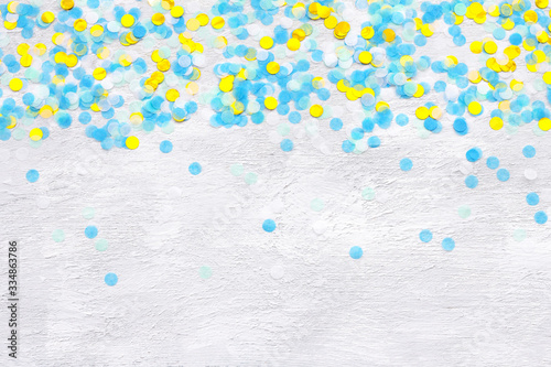 Colorful confetti on light gray background, top view, horizontal	