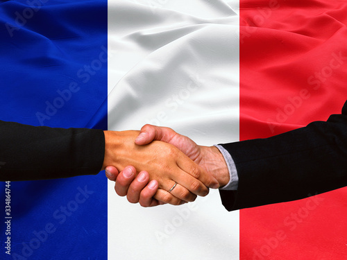 Business handshake on France flag background 