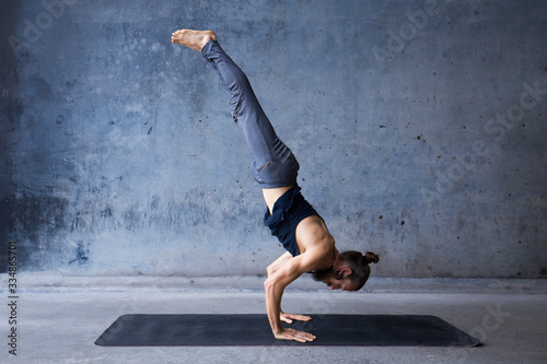 Man practicing yoga, advanced arm balance.  © Luna Vandoorne