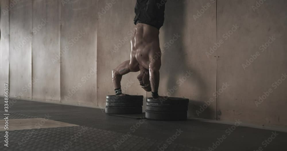 Man doing handstand push ups in gym