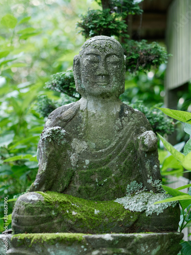 Stone Buddha statue in a garden creating an atmosphere of peace and calm for mindfulness