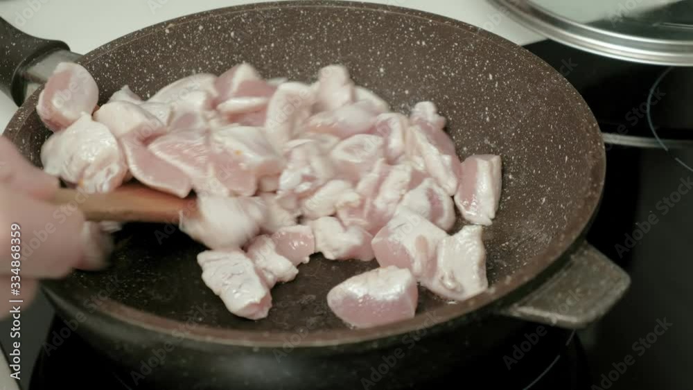 Frying meat in a pan.