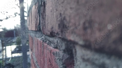 A bullet or projectile hits a brick or wooden wall, and ammunition ricochets off the wall with flying fragments in slow motion