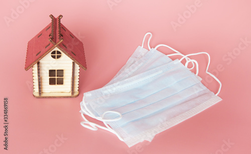 Obraz na płótnie Toy house and medical masks for protection against coronavirus on a pink background w salonie
