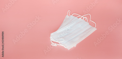 Medical masks to protect a person from the virus and bacteria on a pink background, respiratory tract protection.
