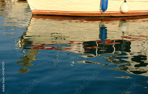 Boats, yachts are on the pier, in the bay. Colorful reflection on the water. Day. Sunny.