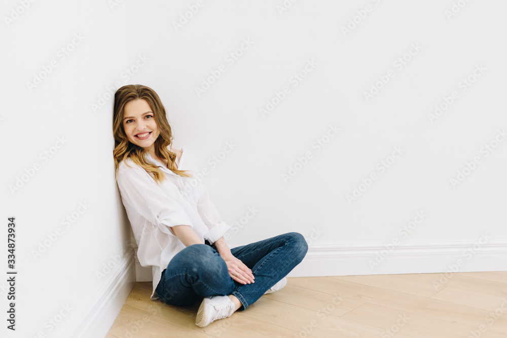 Young beautiful caucasian woman sitting on floor isolated with space for text Young beautiful caucasian woman sitting on floor isolated with space for text