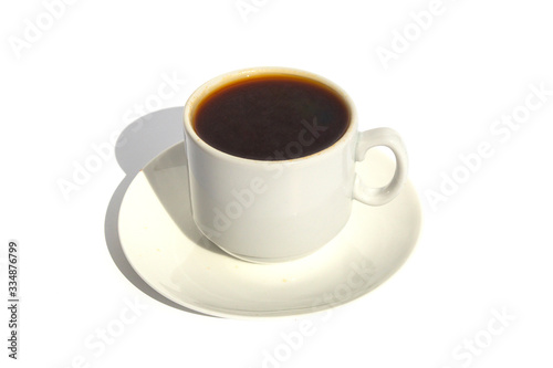 A small cup of espresso on a saucer in the sun