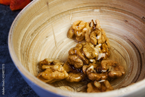Honey and walnuts on a wooden plate