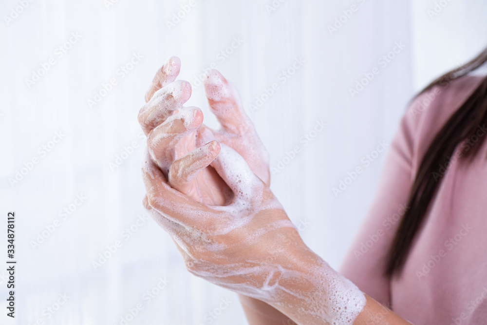 Naklejka premium Closeup woman washing hands with soap on white background. Healthcare and disinfection concept.