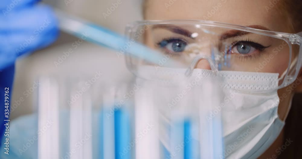 Doctor Carefully Drips Medicine from Pipette into sample glass tubes for DNA analysis at Laboratory