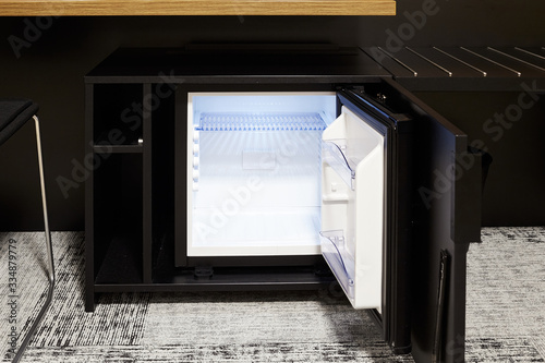 Mini bar with an open door. Mini fridge. Drinks.