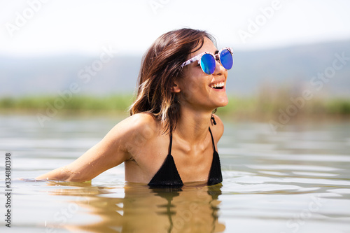 girl with sunglasses in water, happy expression 