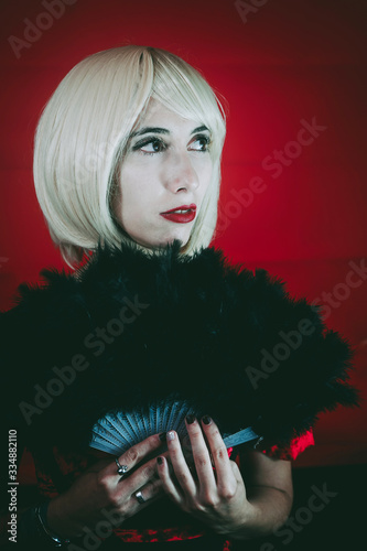 Vintage style portrait of a blonde woman covering by a hand fan photo