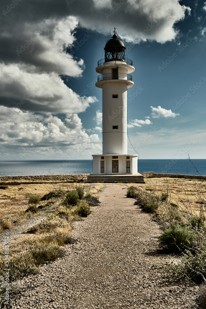 Lighthouse on the Formentera island, Spain, the blue sky with white clouds, without people, rocks, stones, sunny weather
