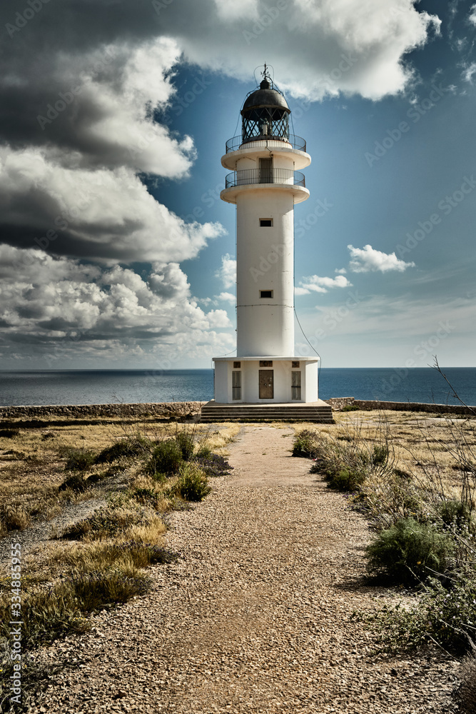 Lighthouse on the Formentera island, Spain, the blue sky with white clouds, without people, rocks, stones, sunny weather
