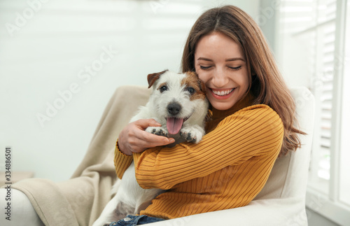 Valokuvatapetti Young woman with her cute Jack Russell Terrier at home