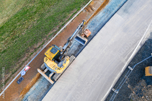 an excavator on an street construction site from above