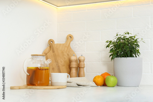 Different kitchen items and houseplant on countertop indoors