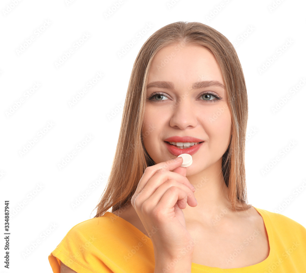 Young woman taking vitamin pill on white background Young woman taking vitamin pill on white background