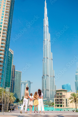 Happy family walking in Dubai with skyscrapers in the background. photo