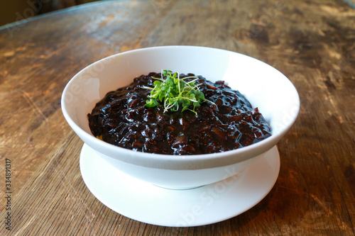 Korean traditional food, Black bean noodles Jajangmyeon on a white bowl and wooden table.C