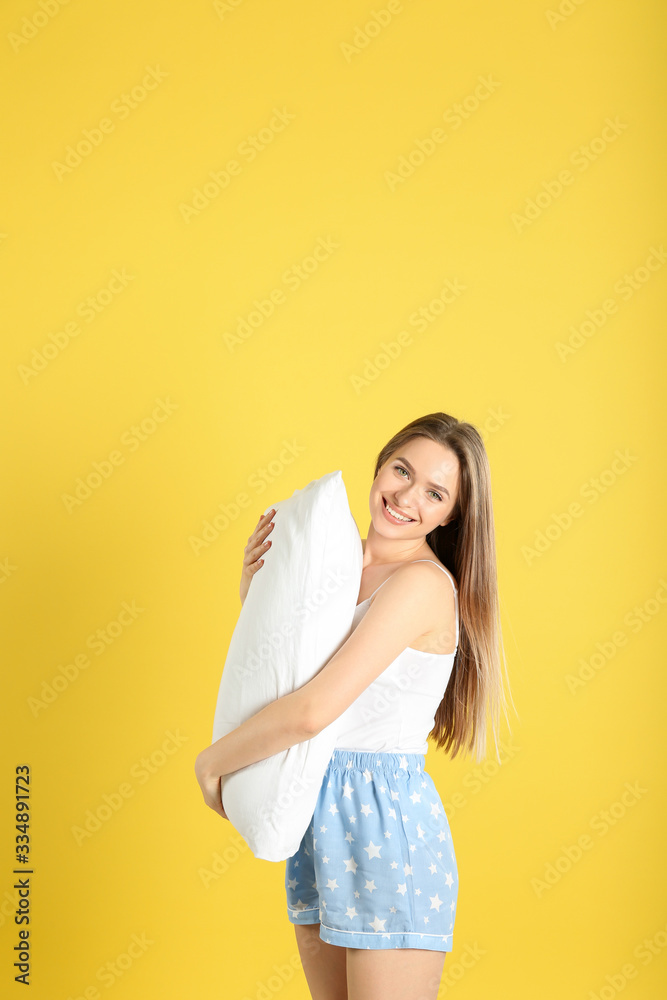 Young woman with pillow on yellow background Young woman with pillow on yellow background