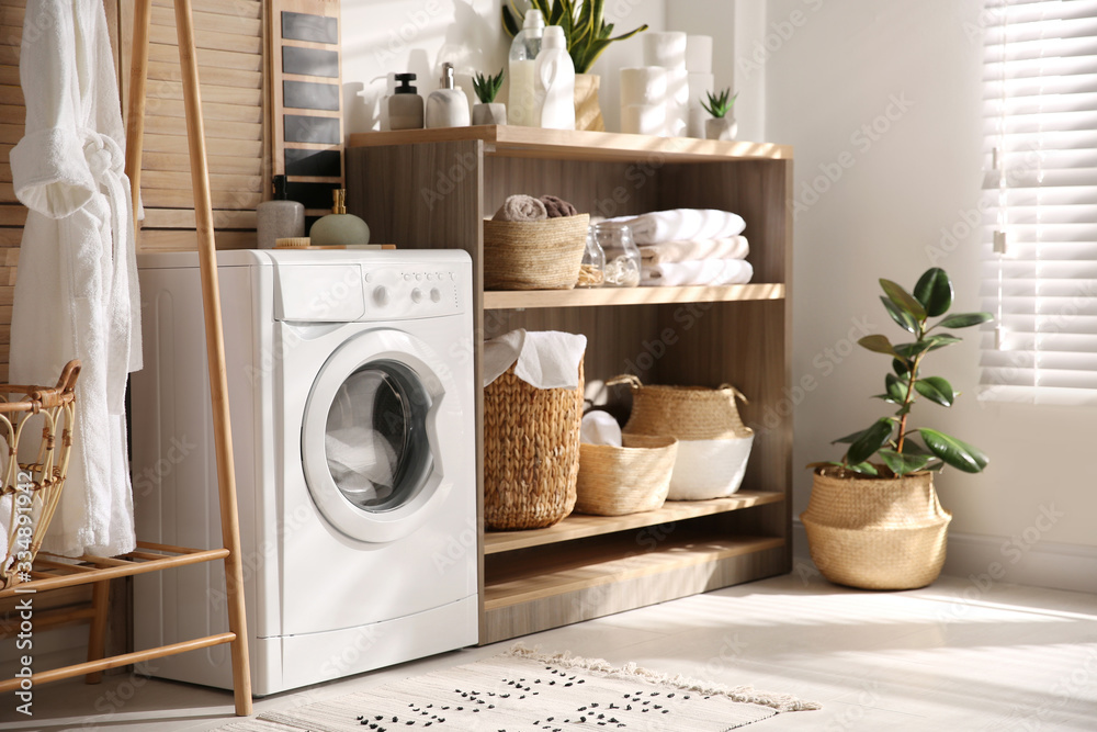 Modern washing machine and shelving unit in laundry room interior - obrazy, fototapety, plakaty 