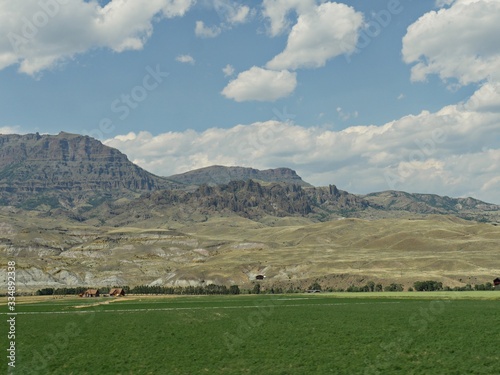 Lush green plains with mountains in the distance, part of the beautiful landscape of Wyoming.