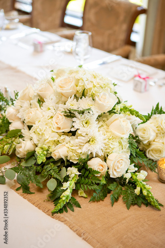 Bouquet of roses and daisies on a table set for a wedding party