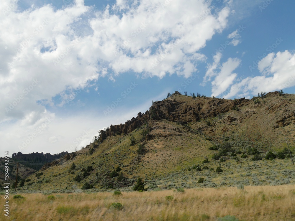 Mountainside landscape with beautiful clouds in the skies seen from North Fork Highway in Wyoming.