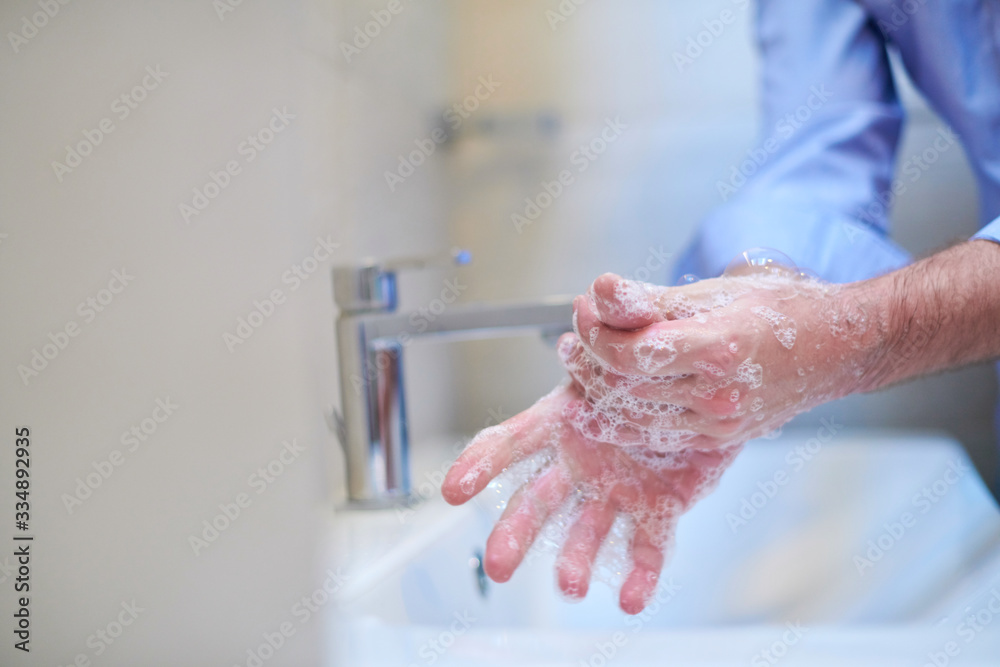 Fototapeta premium coronavirus male wahing hands in bathroom