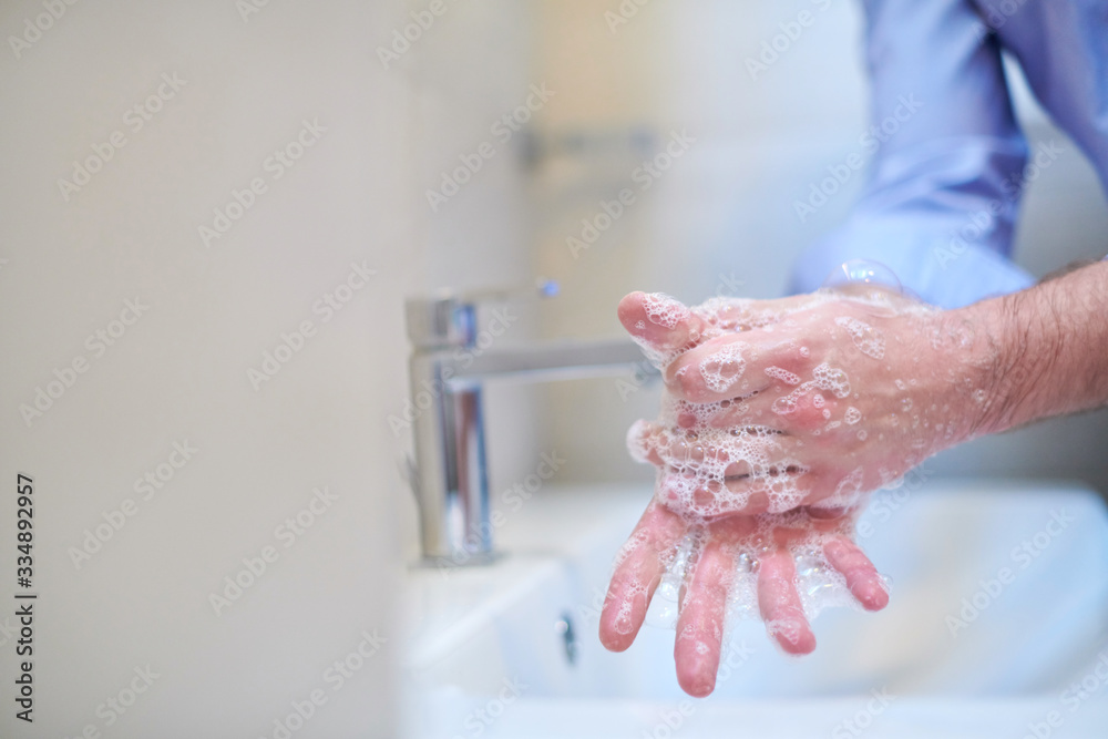 Fototapeta premium coronavirus male wahing hands in bathroom