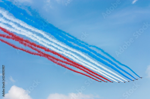 Cores da bandeira da frança feita de fumaça por aviões em dia limpo com céu azul.