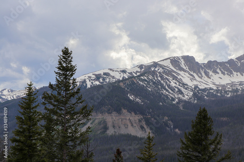 A view of the snow covered Colorado mountains and cloudy skies 
