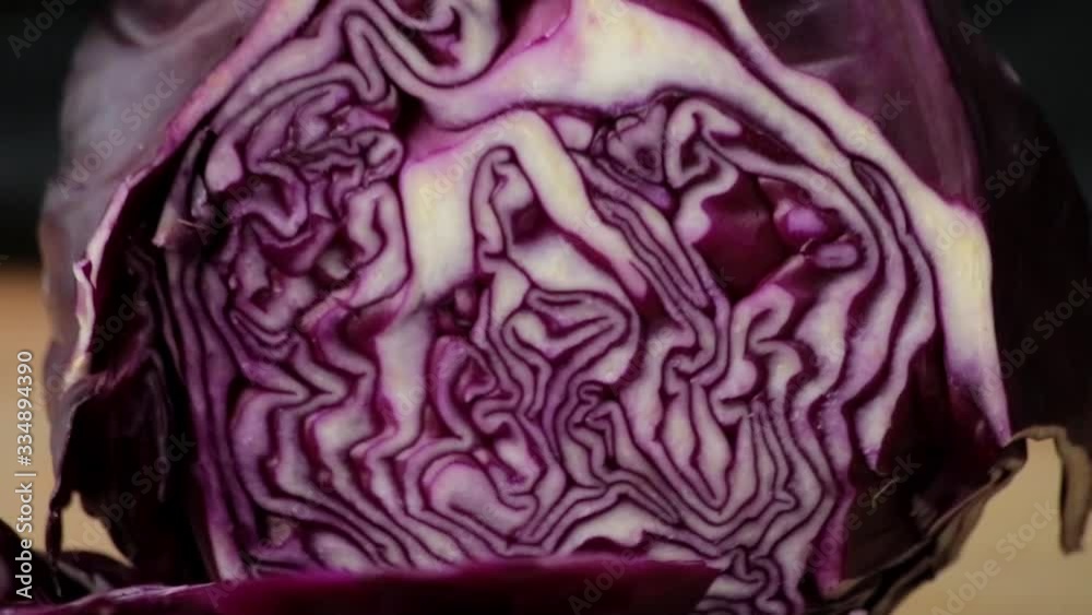 The cook cuts red cabbage with a sharp knife on a cutting board The cook cuts red cabbage with a sharp knife on a cutting board