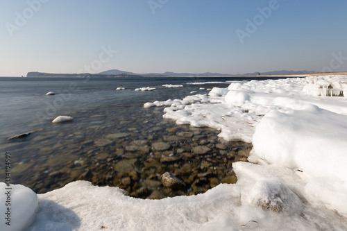 icy seashore, mountains in the background
