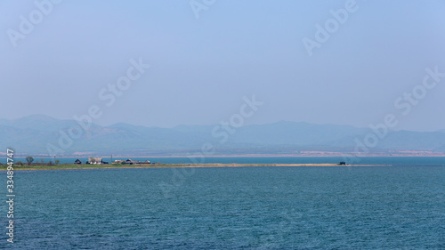 coastal spit with a house on a background of mountains