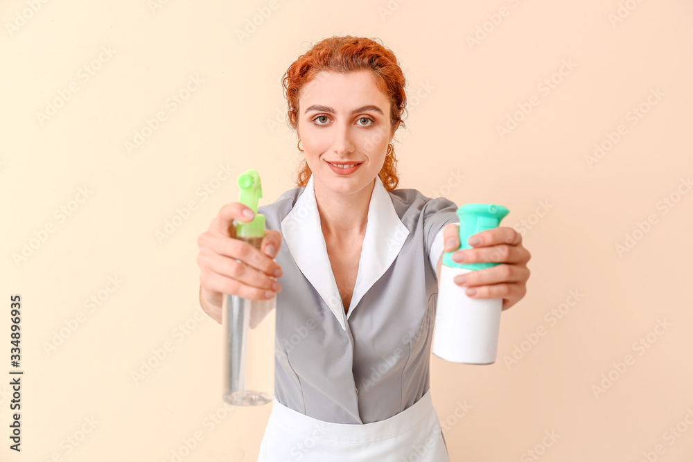Beautiful young chambermaid on color background Beautiful young chambermaid on color background