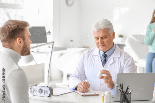 Doctor giving pills to youn...