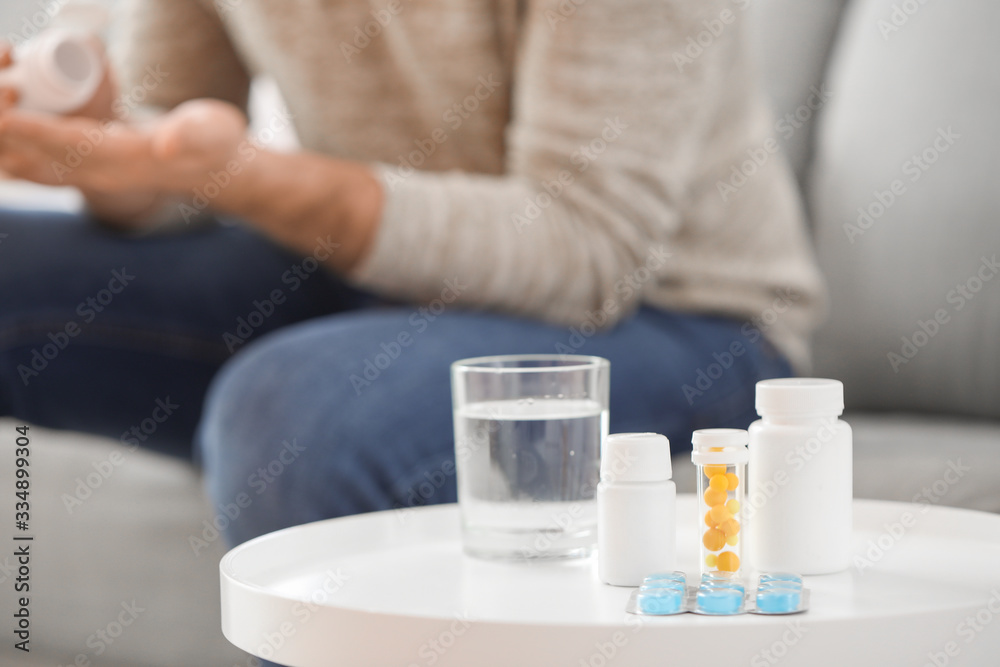 Medicines and glass of water on table Medicines and glass of water on table