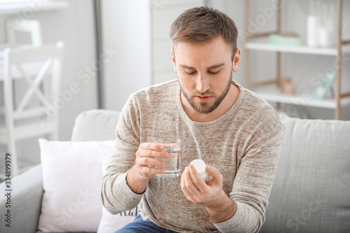 Young man taking medicine a...
