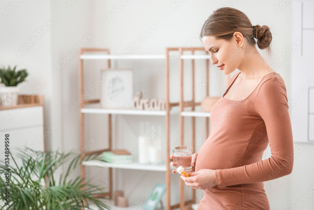 Young pregnant woman with medicines at home