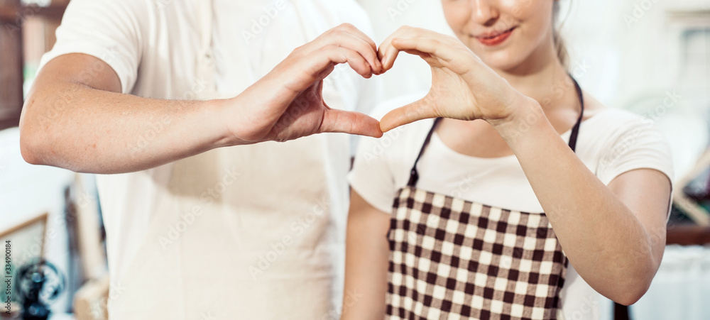 Fototapeta premium banner hand of couple making gesture heart with love together, man and woman standing in the kitchen at home, just married people, self quarantine lifestyle during coronavirus outbreak crisis