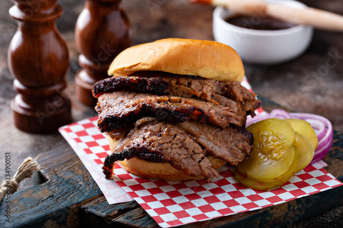Smoked barbeque beef brisket sandwich with pickles photo
