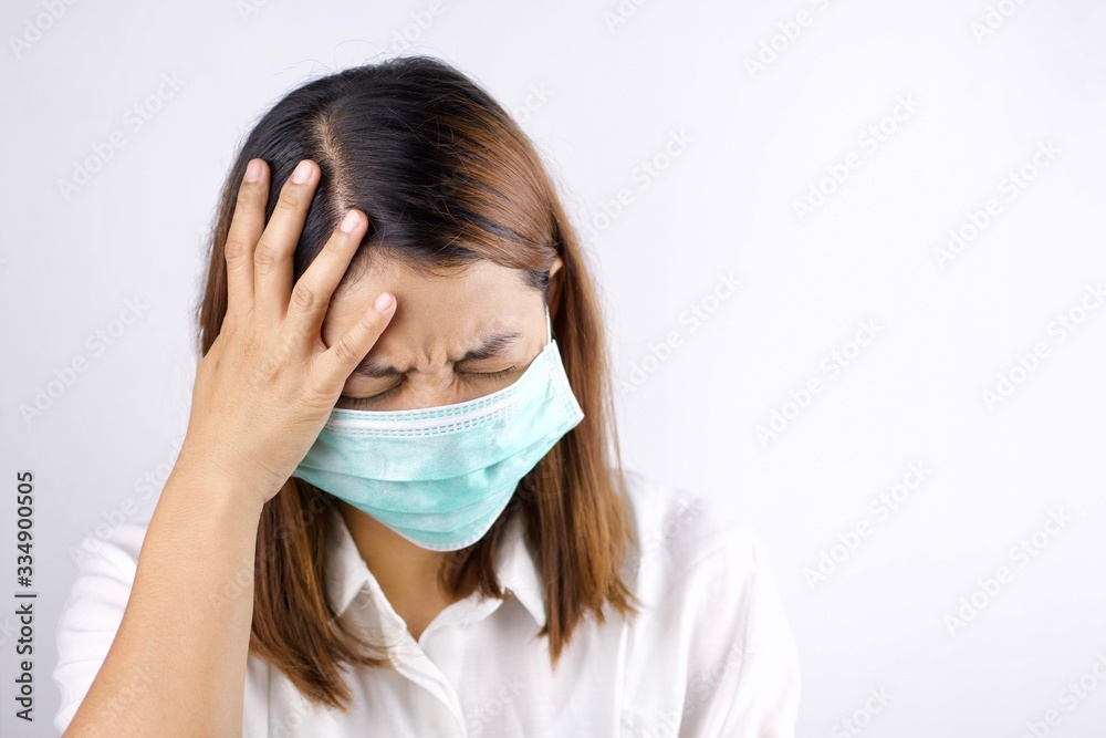 Health concepts, women wearing sanitary masks and handles in the head area She is sick and has a fever. Due to getting a virus or caused by a weak body. Health concepts, women wearing sanitary masks and handles in the head area She is sick and has a fever. Due to getting a virus or caused by a weak body.