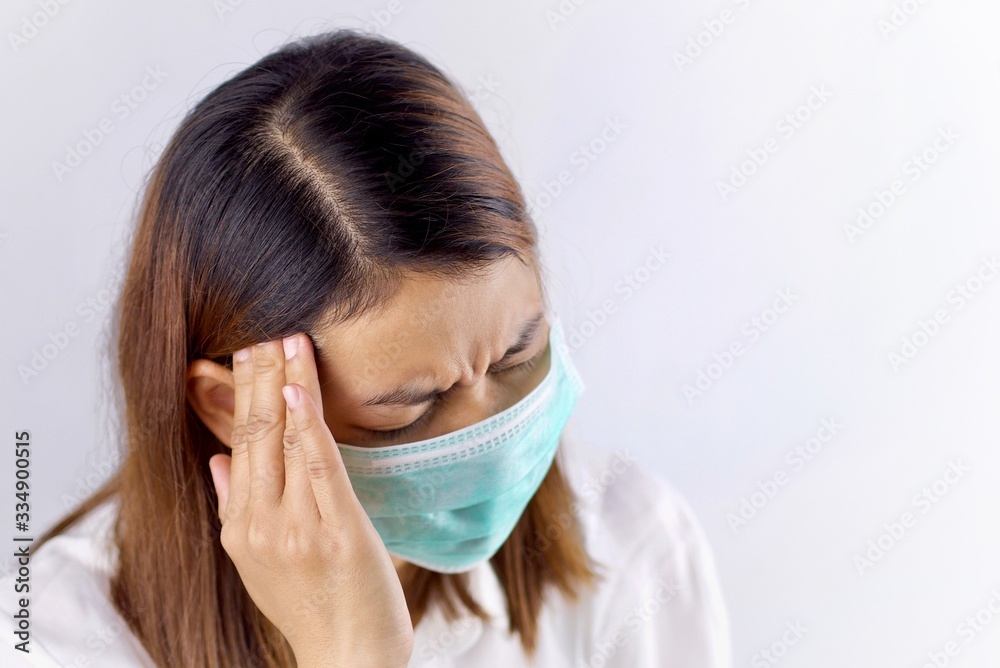 Health concepts, women wearing sanitary masks and handles in the head area She is sick and has a fever. Due to getting a virus or caused by a weak body. Health concepts, women wearing sanitary masks and handles in the head area She is sick and has a fever. Due to getting a virus or caused by a weak body.