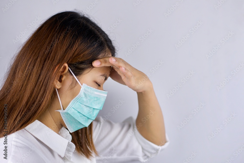 Health concepts, women wearing sanitary masks and handles in the head area She is sick and has a fever. Due to getting a virus or caused by a weak body. Health concepts, women wearing sanitary masks and handles in the head area She is sick and has a fever. Due to getting a virus or caused by a weak body.