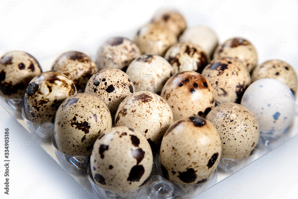 tray with colorful small quail eggs on a white background close-up. dietary health food tray with colorful small quail eggs on a white background close-up. dietary health food