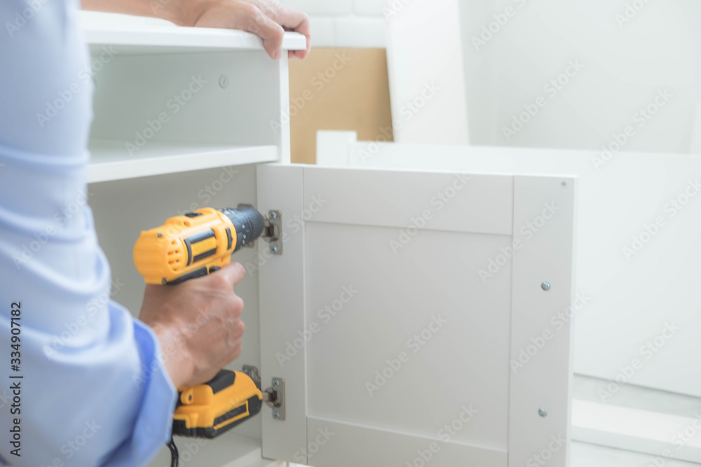 Obraz premium The mechanic assembled the furniture in the house according to the manual, along with the mechanic equipment. By hammering the nails Measuring with a tape measure Screwing the screw Drilling holes.